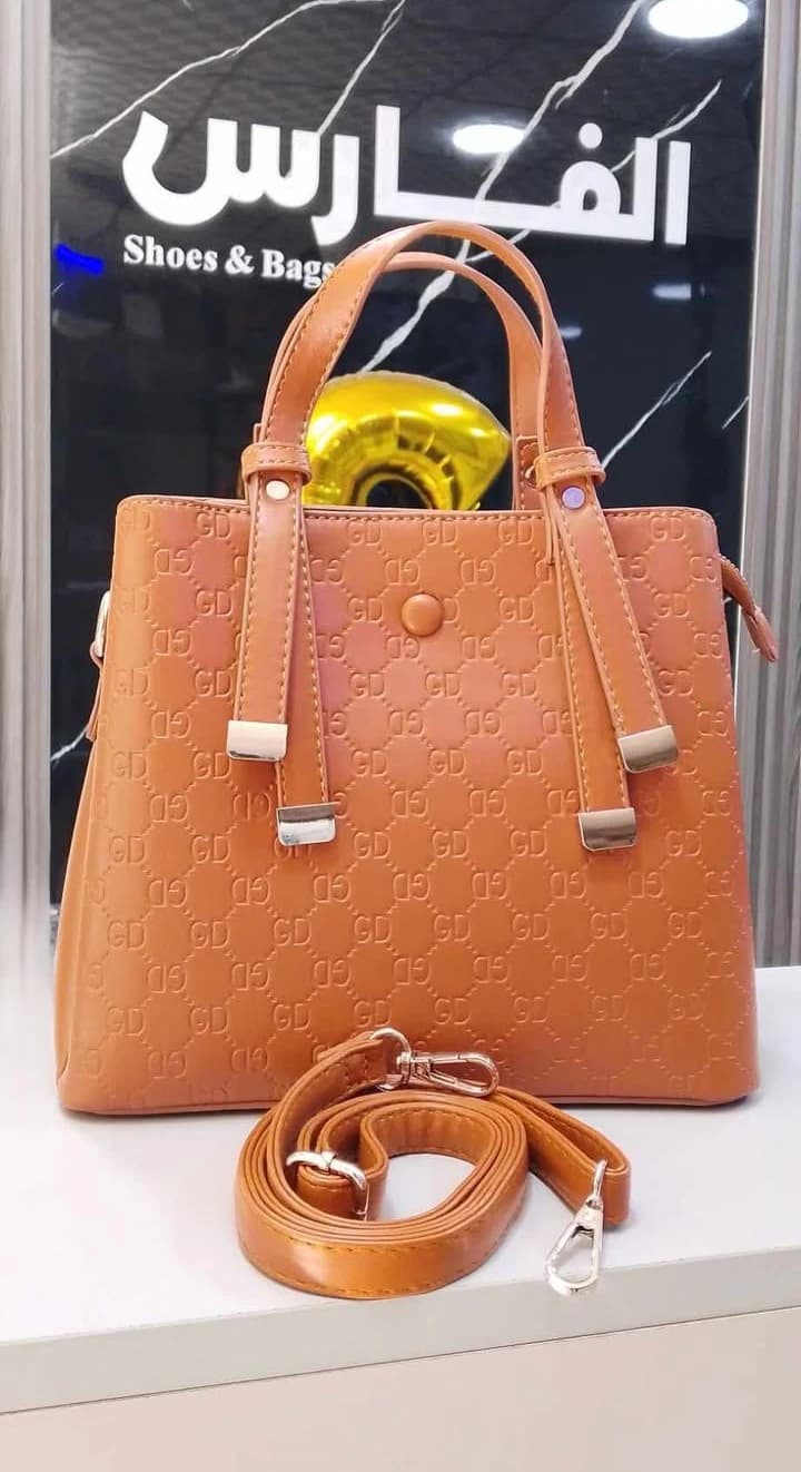 A classic-style handbag with top handles and gold-tone hardware for women.