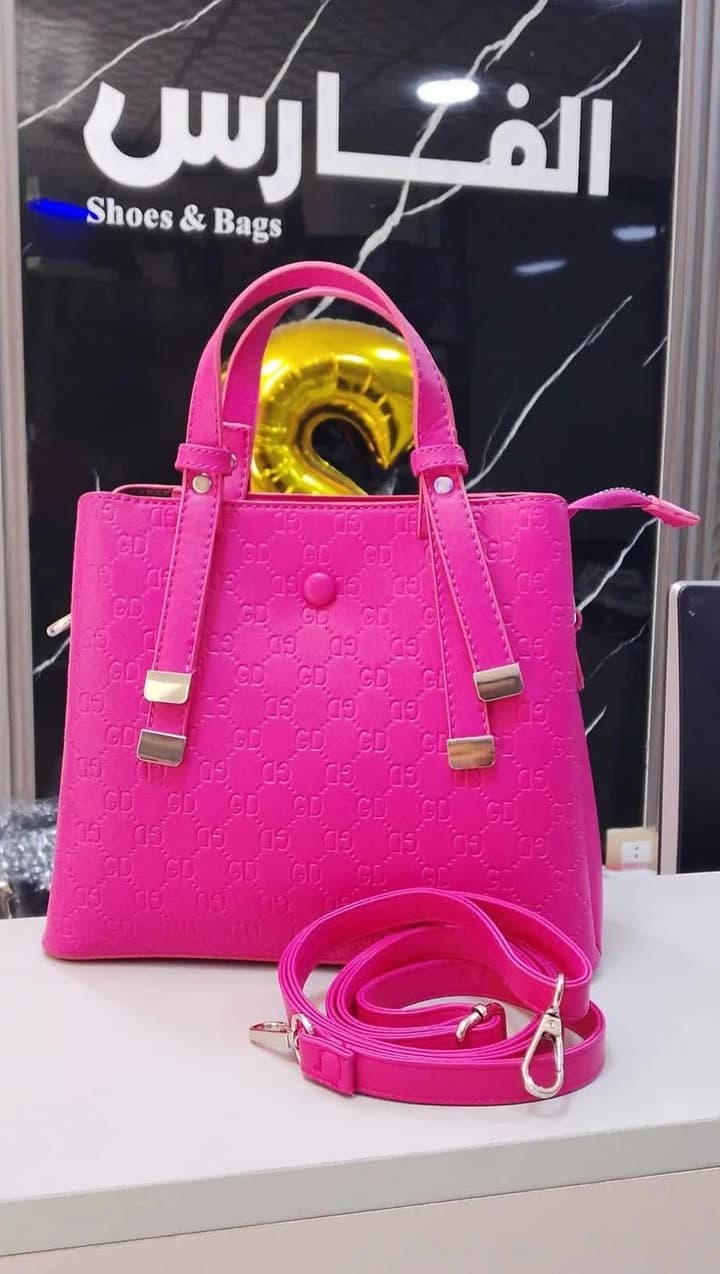 A classic-style handbag with top handles and gold-tone hardware for women.