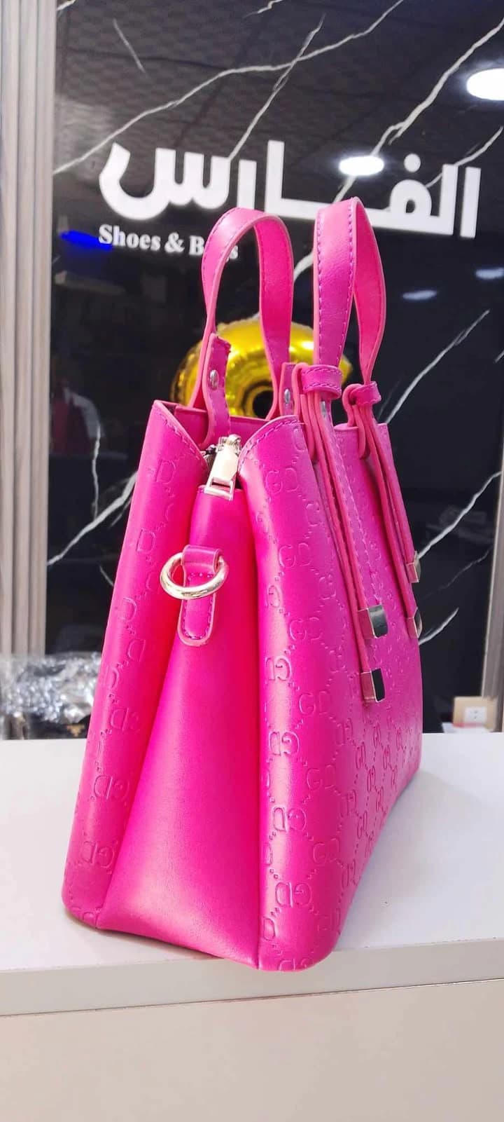 A classic-style handbag with top handles and gold-tone hardware for women.