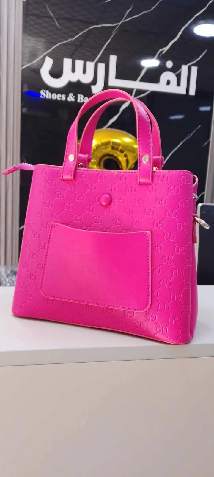 A classic-style handbag with top handles and gold-tone hardware for women.